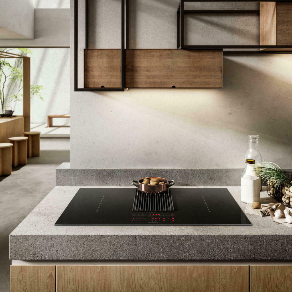 Black Elica induction cooktop with red illuminated controls in a modern kitchen with wood cabinets. A small pot sits on the cooktop.