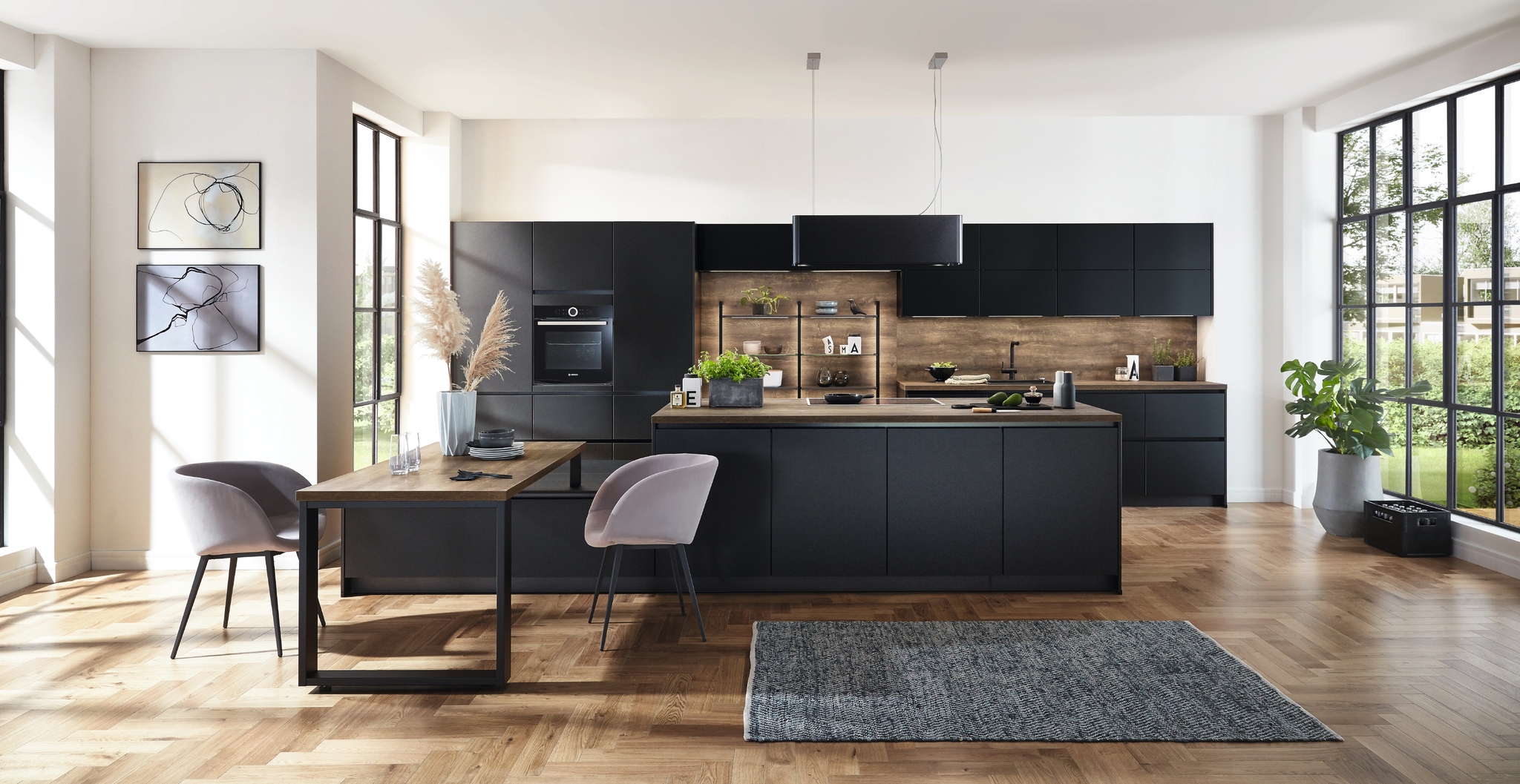Sleek, modern black kitchen with a matching island, dark wood countertop, and light wood flooring. Purple accent chairs add a pop of color.