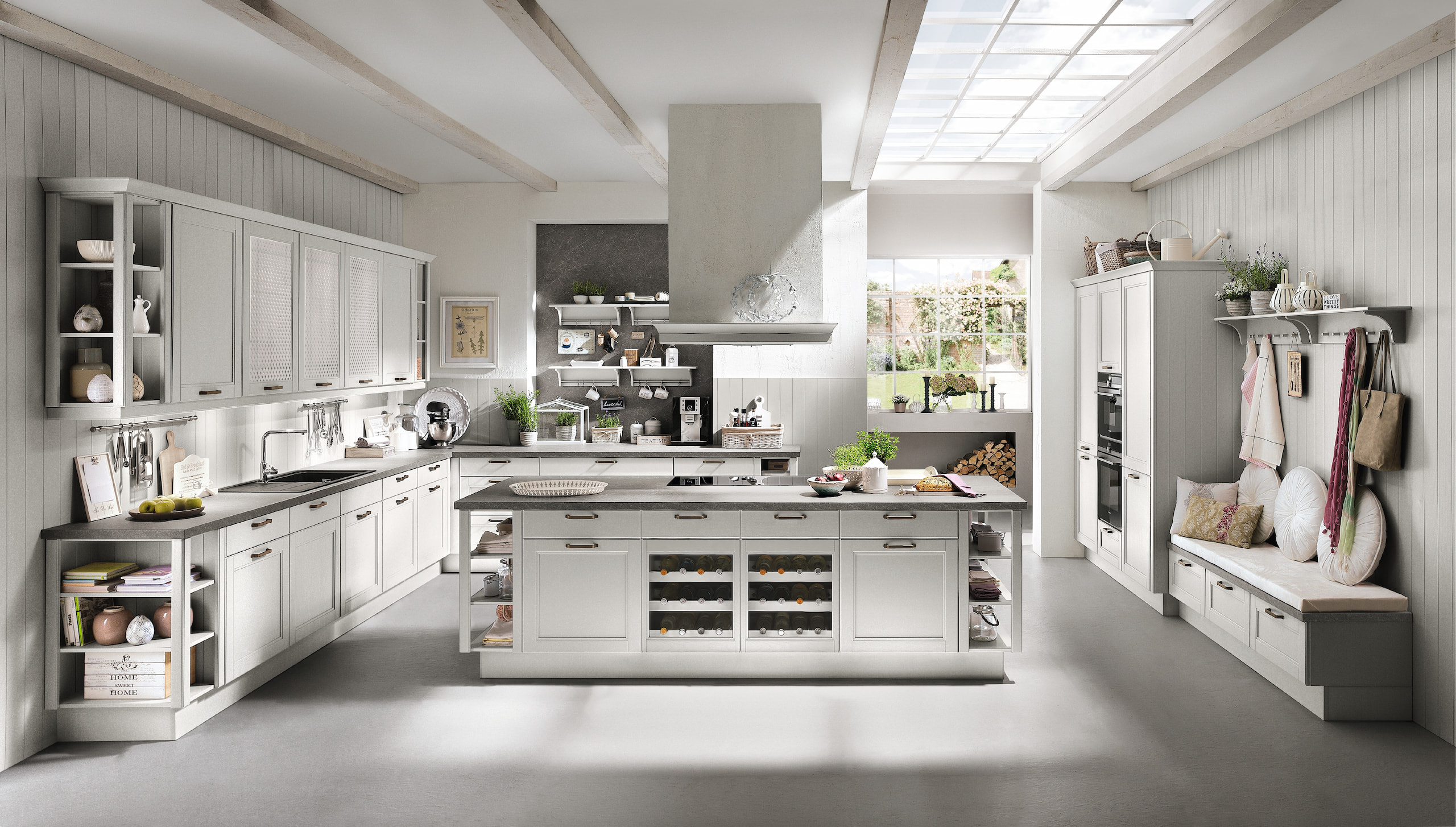 Bright, spacious traditional kitchen with white cabinets, wood accents, a large island, a skylight, and ample storage.