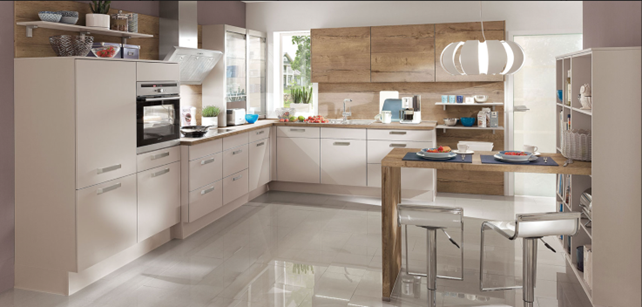 Modern L-shaped kitchen interior design with light-colored cabinets, wooden accents, and a cozy dining area, illustrating tips and trends for a functional and stylish kitchen layout.