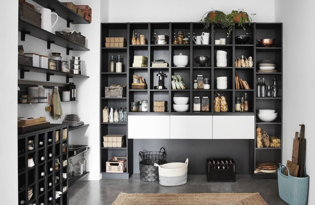 A contemporary black-and-white kitchen with an open shelving system, emphasizing modern kitchen interior design that offers both functionality and style.