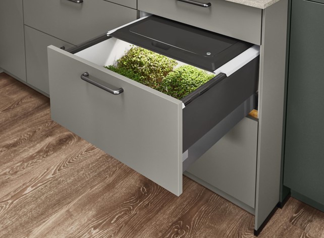 An innovative indoor herb garden housed within a kitchen drawer, highlighting a unique feature of eco kitchen design that promotes sustainable practices.