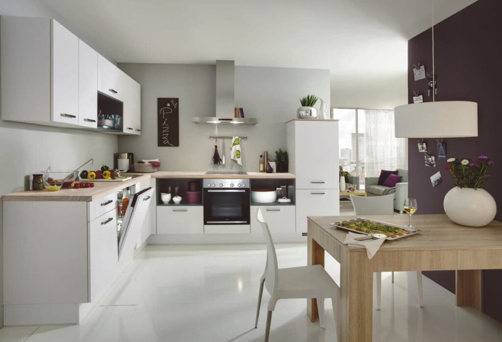 A practical and stylish kitchen with built-in furniture, including a dedicated dining area. The white cabinets create a bright and airy feel.