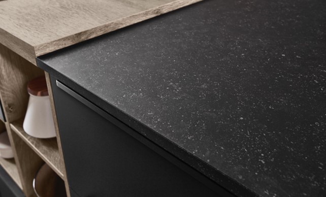 Close-up of kitchen top ideas featuring a combination of durable black granite and wood countertops, showcasing a stylish and functional kitchen design.