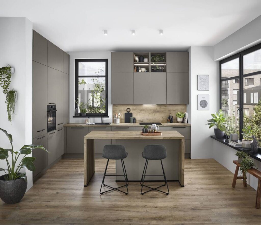 A sophisticated German kitchen in olive green with a wooden island