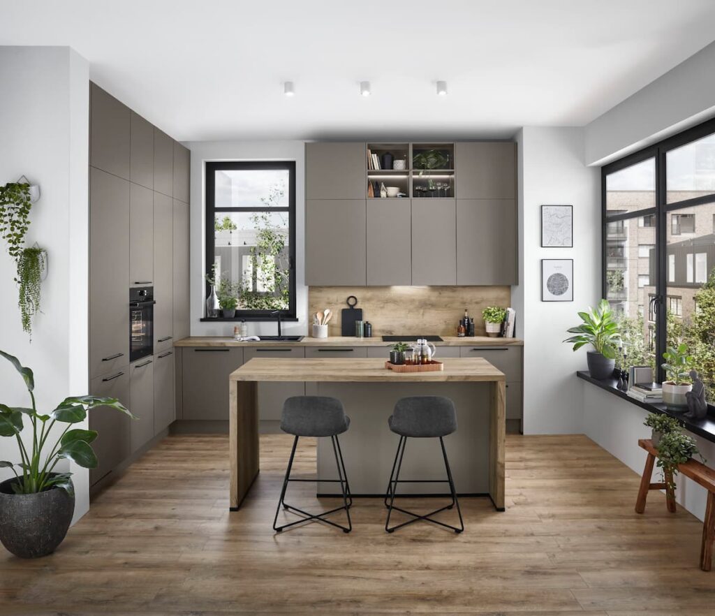 An urban L-shaped modular kitchen interior design in soft gray hues, enhanced by modern plants and open windows for an airy, city-inspired ambiance.