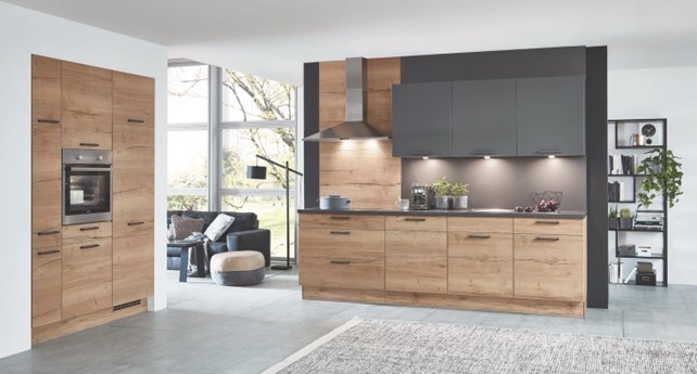 Close-up of a glass-fronted kitchen cabinet with integrated lighting, highlighting the quality and craftsmanship often associated with the best material for kitchen cabinets. Drinking glasses are neatly arranged on the glass shelves.